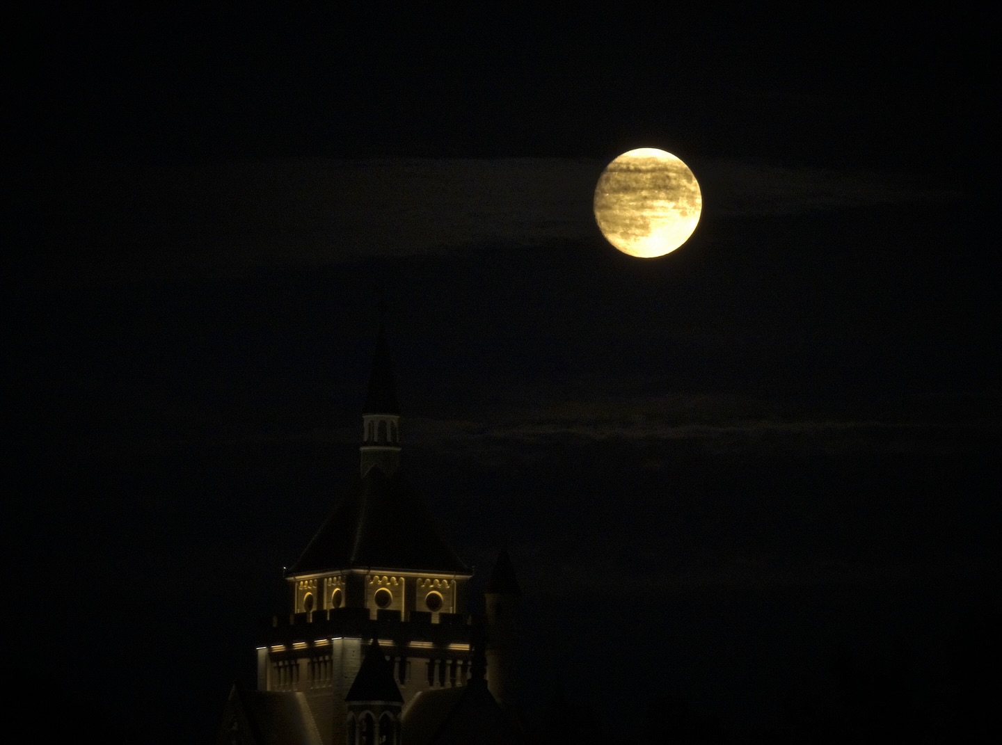 Lune jaune dans la nuit noire traversée par un nuage